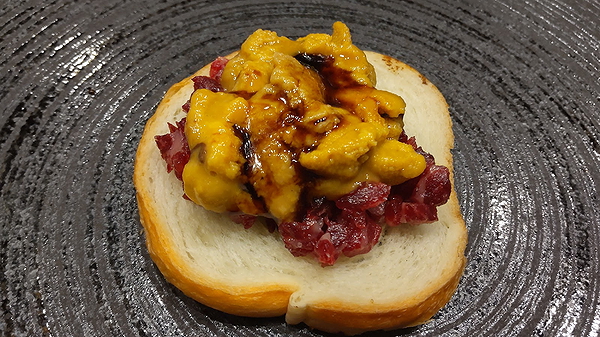Gourmet sandwich with cured meat and cheese topping
