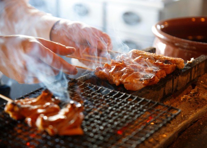 A craftsman grilling yakitori Japanese food skewers chicken