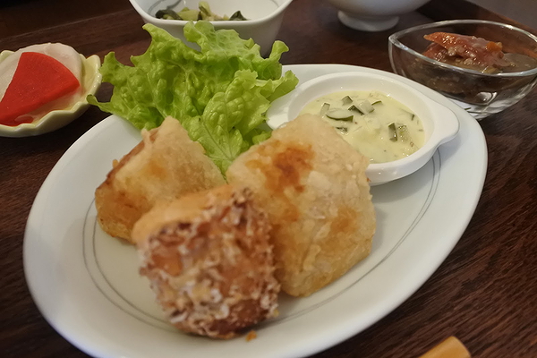 Crispy tofu bites with dipping sauce and lettuce garnish