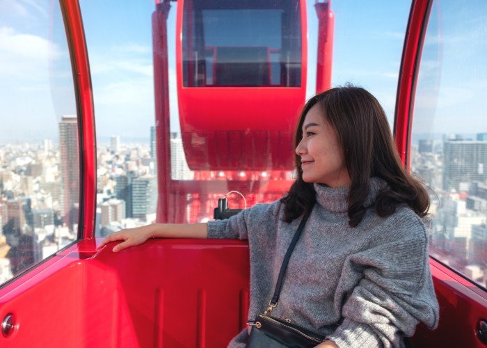 woman riding a red ferris wheel in Japan