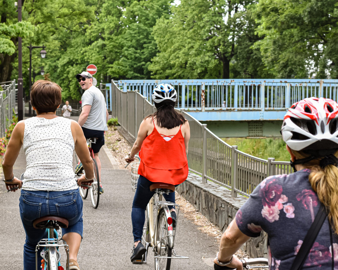 A group of people cycling through the city on a Tokyo bike tour.