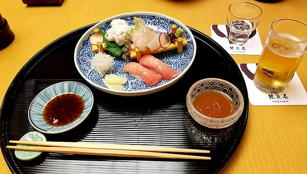 Elegant Japanese sushi platter with drinks on restaurant table