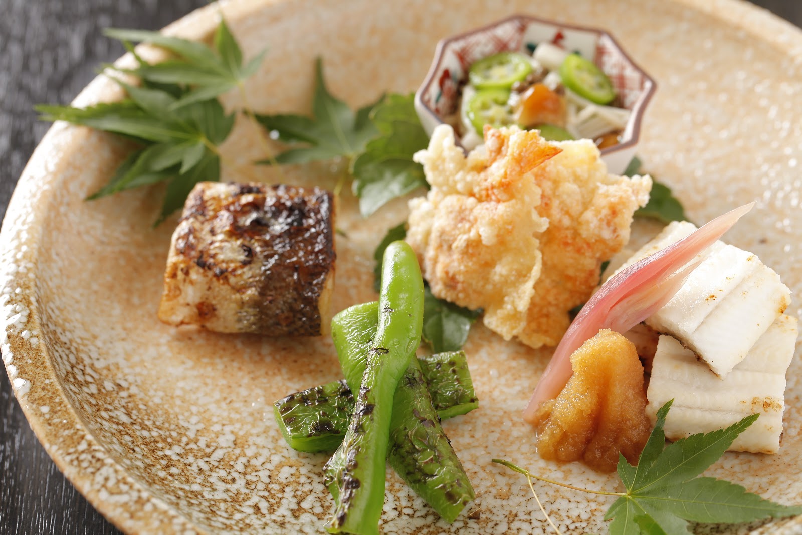Elegant Japanese cuisine with grilled fish and vegetables on a ceramic plate
