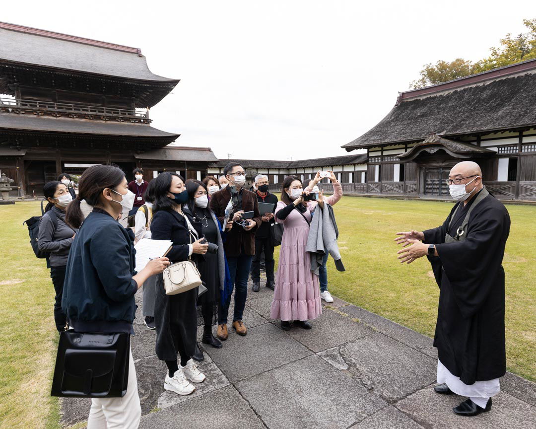 A priest at Zuiryuji Temple guiding tour guests around the temple.