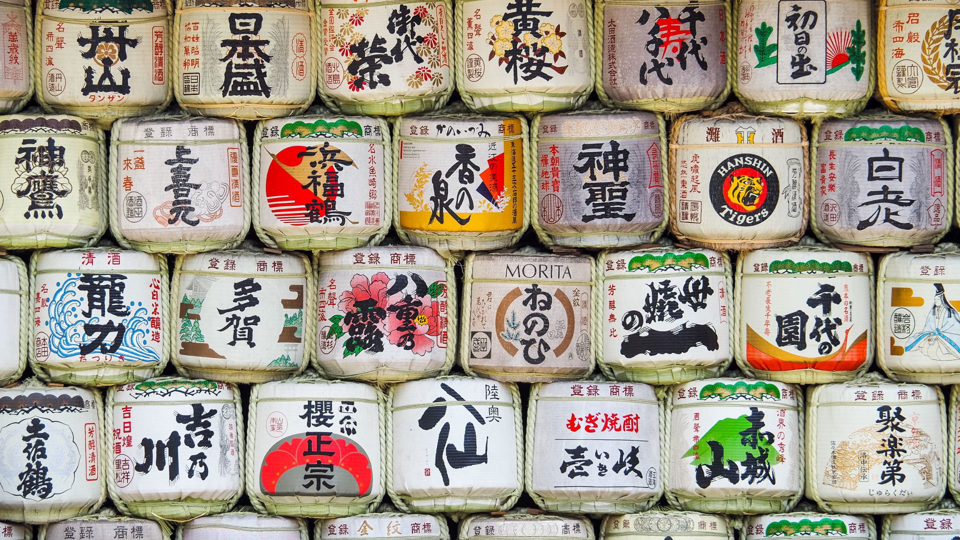 Stacked Japanese sake barrels with colorful kanji designs