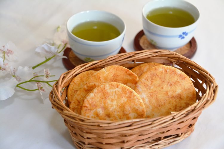 Senbei in a basket and a cup of green tea