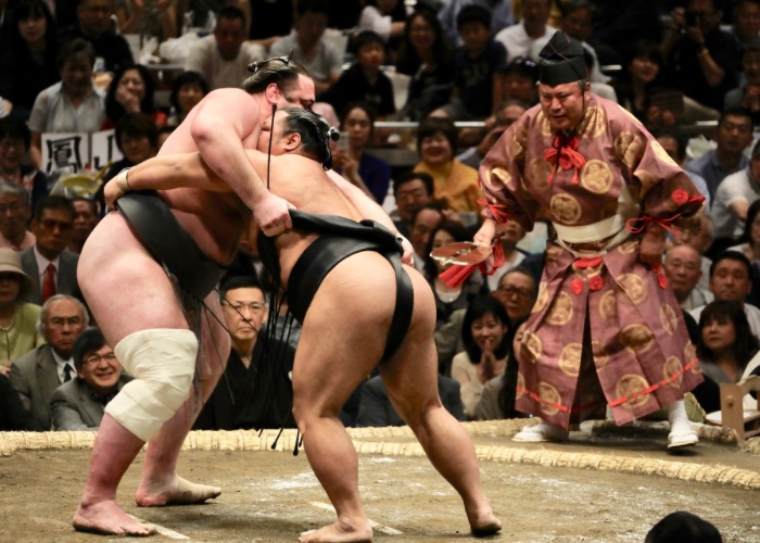 Two sumo wrestlers locked together in a match.