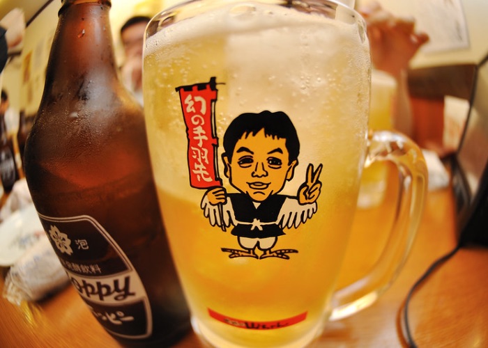A glass of beer with Sekai no Yamachan's mascot.