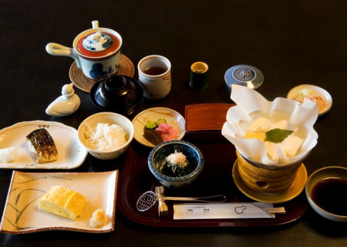 The multiple dishes of a traditional Japanese breakfast, including fish, rice, soup and more.