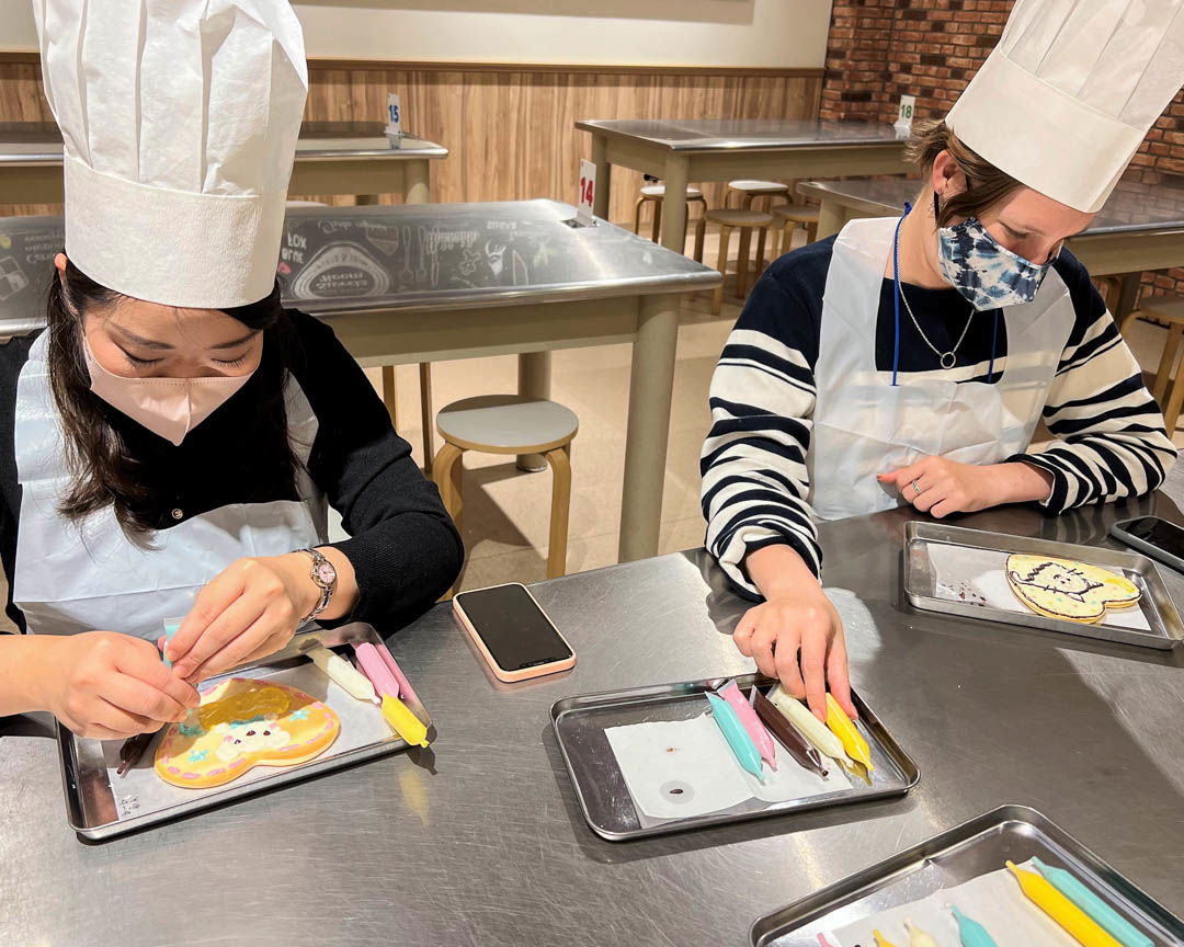 Two people designing Shiroi Koibito cookies at an experience in Sapporo