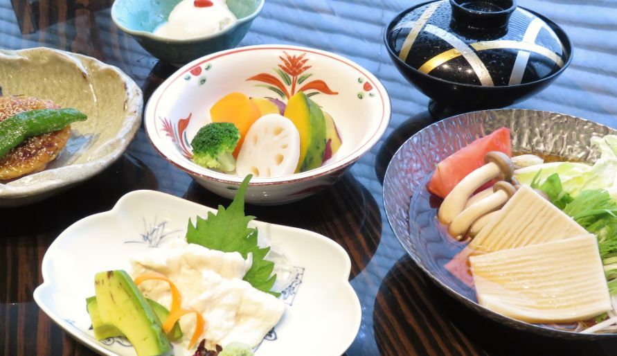 Traditional Japanese course menu with assorted vegetables and tofu
