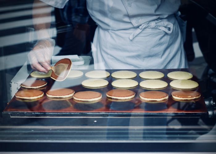 A chef is making dorayaki, a type of Japanese dessert which is like a pancake filled with sweet red bean paste