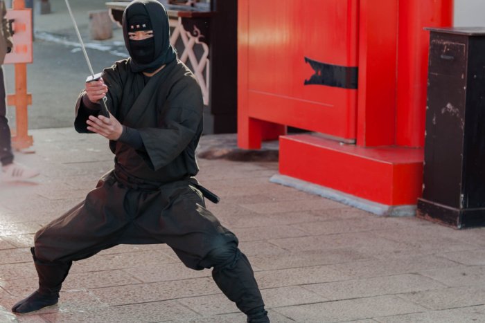 A ninja holding a katana, on the street in Japan