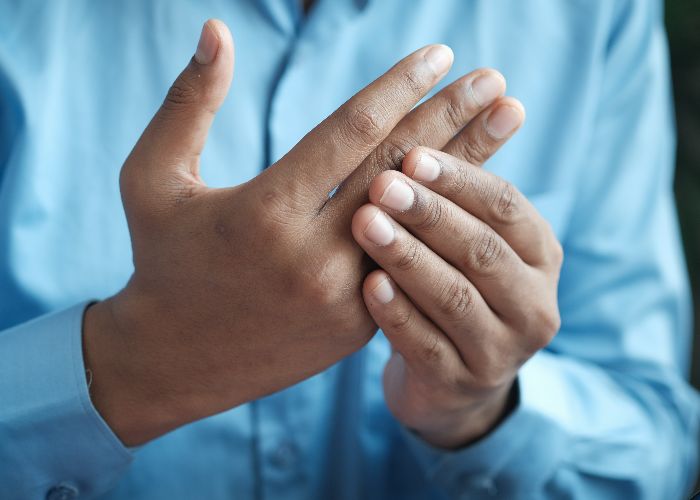 A man massaging his own hand as if it were in pain