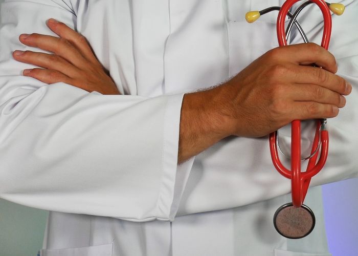 Doctor standing with arms crossed holding a stethoscope 