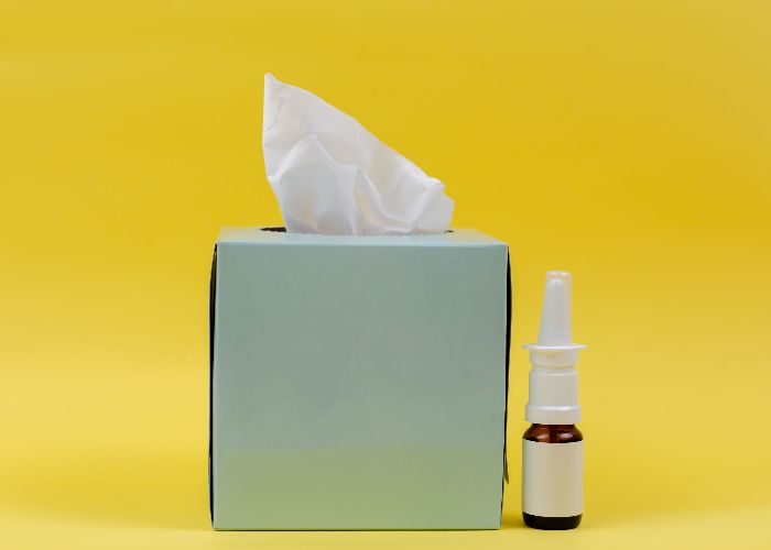 A box of tissues and nose spray
