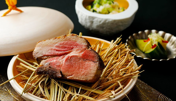 Gourmet steak on straw with side dishes at a fine dining restaurant