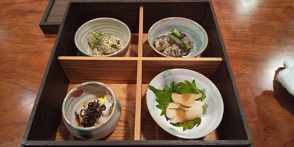 Elegant Japanese appetizer platter with four gourmet selections