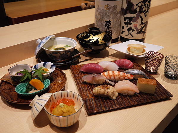 Exquisite sushi platter with sake bottles on a wooden table