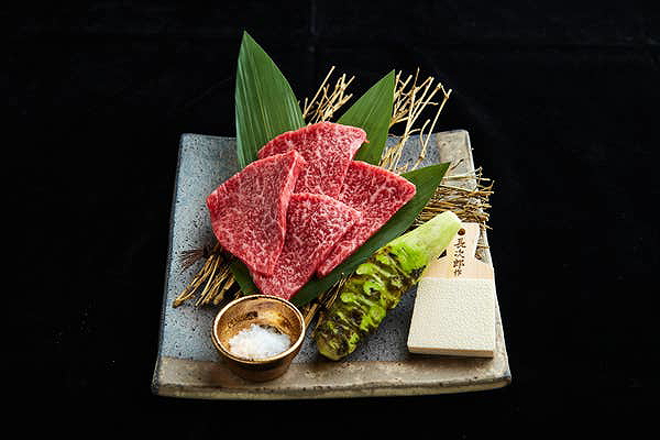 Premium wagyu beef slices with wasabi and salt on stone plate