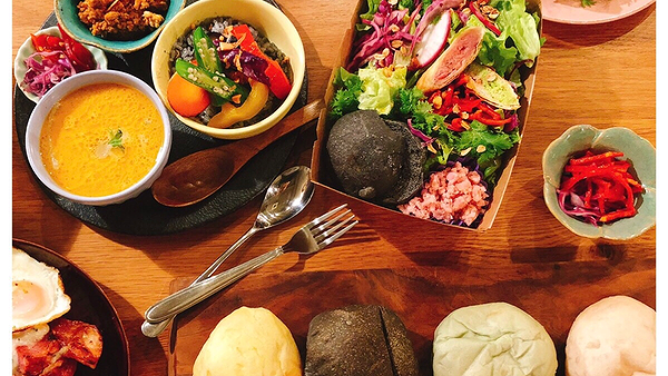 Colorful gourmet dishes on a wooden table in a vibrant restaurant setting
