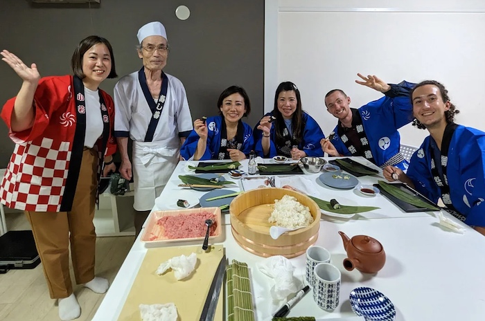 Participants wave in an Osaka sushi class