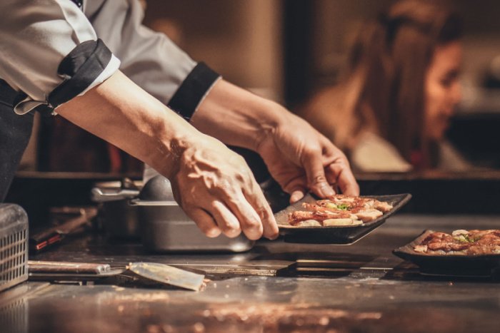 A chef serves grilled Japanese-style meat