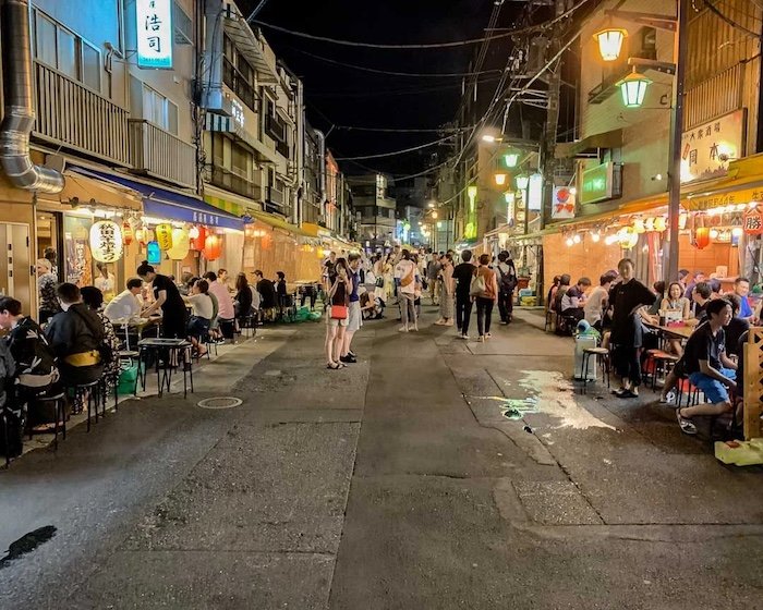 People drink in a izakaya street in Asakusa on a hot summer night
