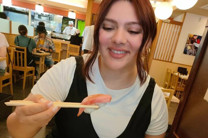 A guest on an Ikebukuro food tour about to eat sushi.