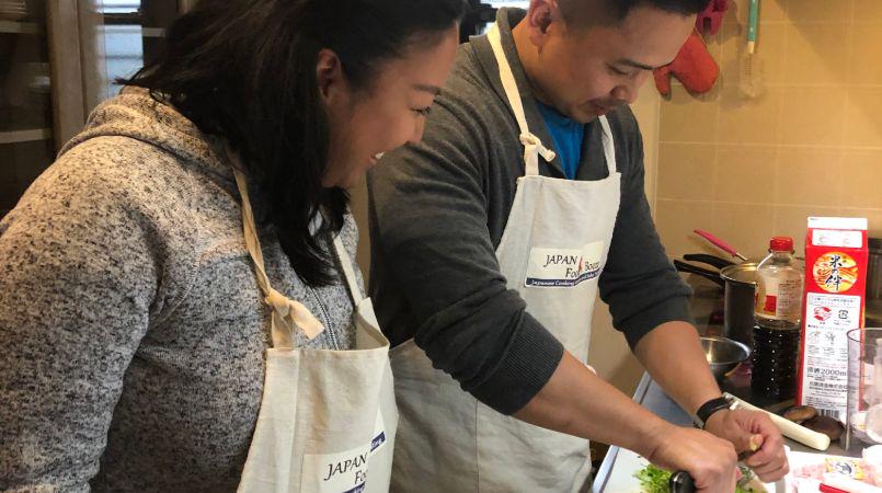 A guest at a cooking class being instructed by the expert guide.