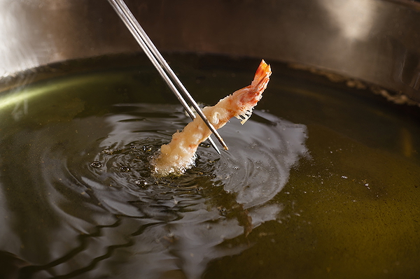 Crispy tempura shrimp being freshly fried in hot oil