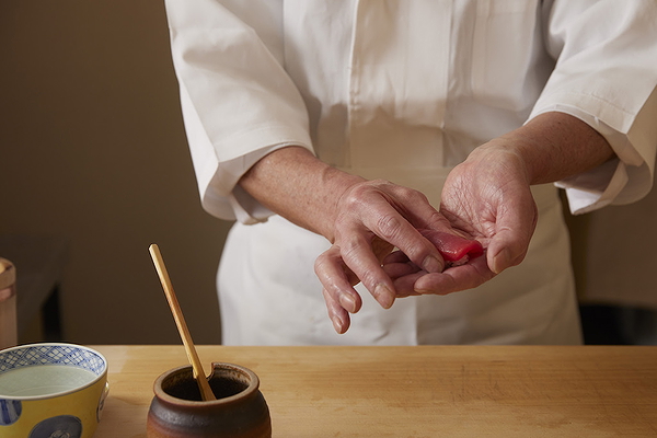 Chef preparing sushi at a Japanese restaurant, hands forming perfect nigiri