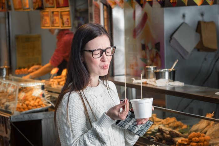A woman pulls a face as she eats spicy food