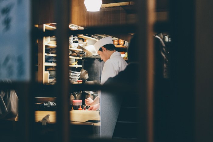 Peeking in on a Japanese chef working in a kitchen