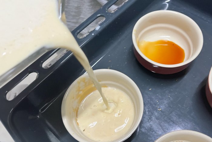 Pouring a Japanese pudding mix into ramekins
