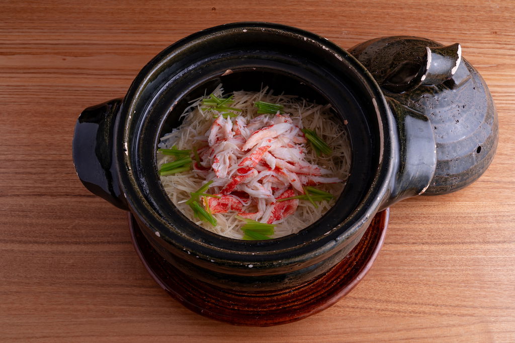 Elegant seafood dish in traditional black pot on wooden table