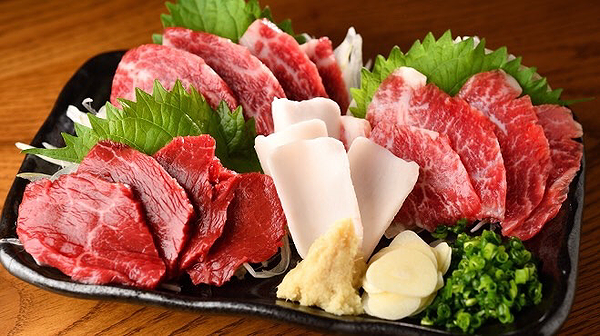 Japanese wagyu sashimi platter with garnish on black plate
