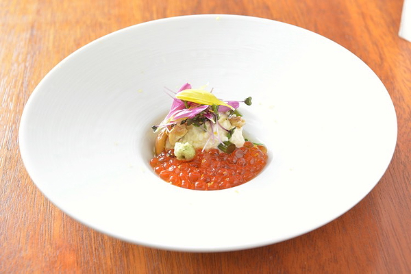 Gourmet dish with roe and microgreens on a white plate