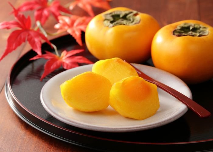Japanese persimmons, a staple fall food in Japan, presented on a platter.