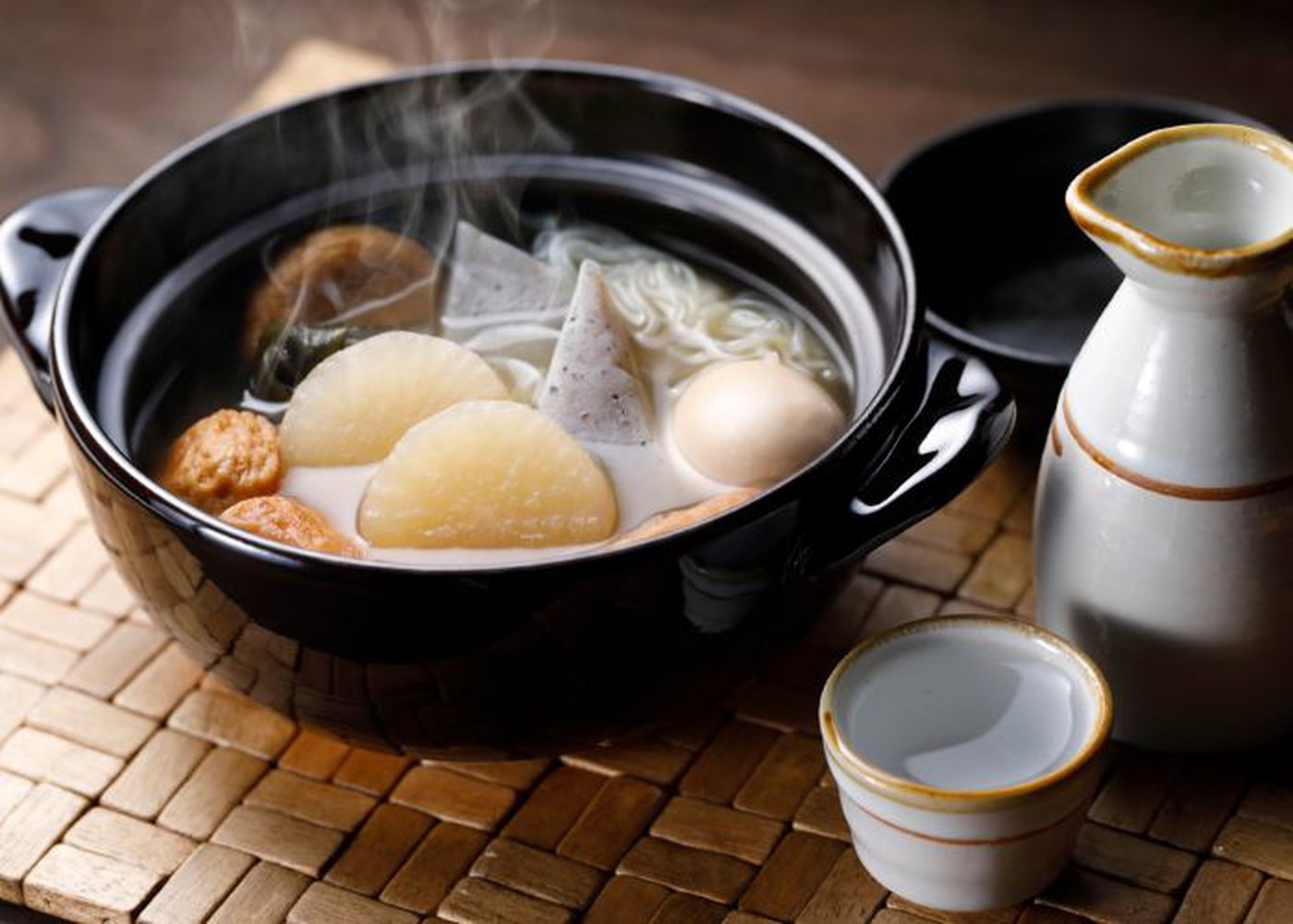A bowl of steaming-hot oden served alongside sake, an autumn staple in Japan.