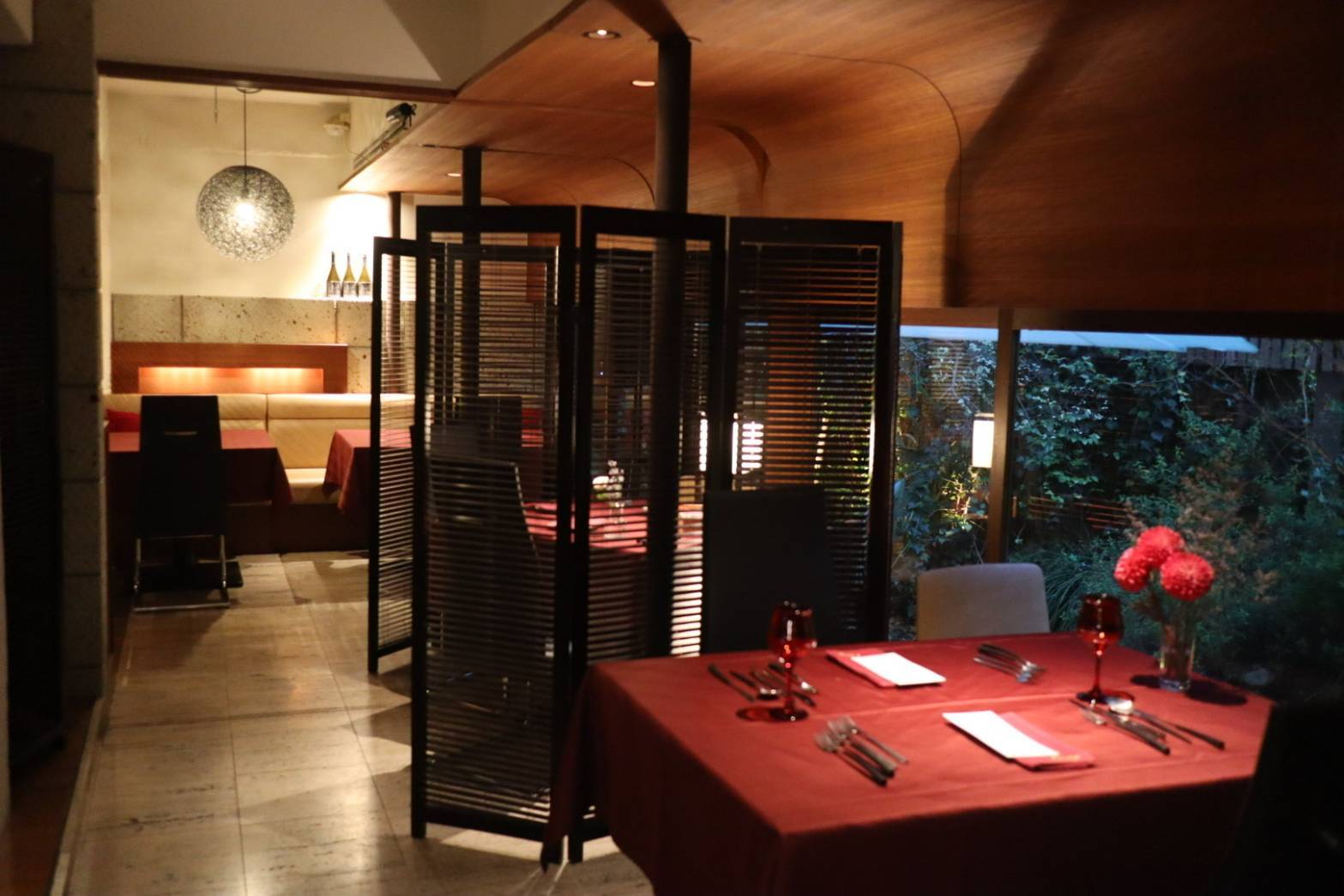 The stylish interiors of Courage, blending dark woods with red tables.