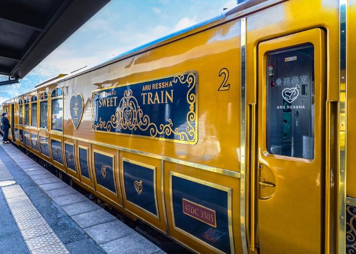 A shot of the yellow exterior of the Aru Ressha sightseeing train.