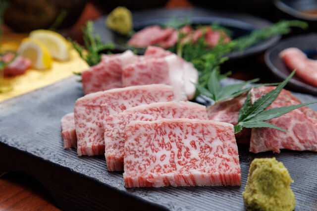 Thinly sliced wagyu beef on a platter with garnish for gourmet dining