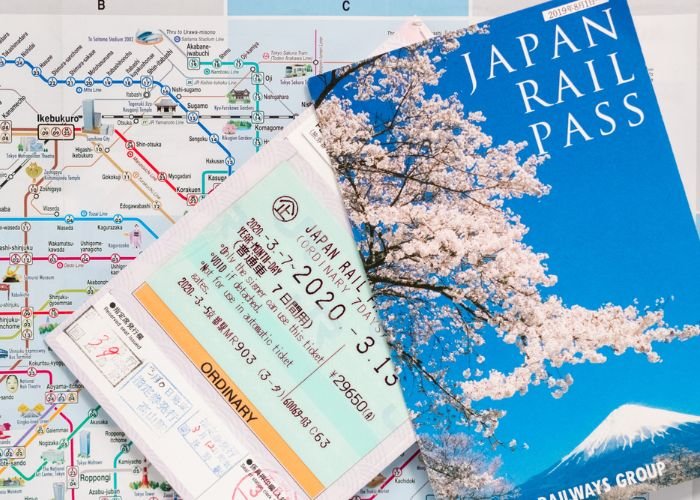 A photo of the Japan Rail Pass (JR Pass) on top of a Tokyo subway map.