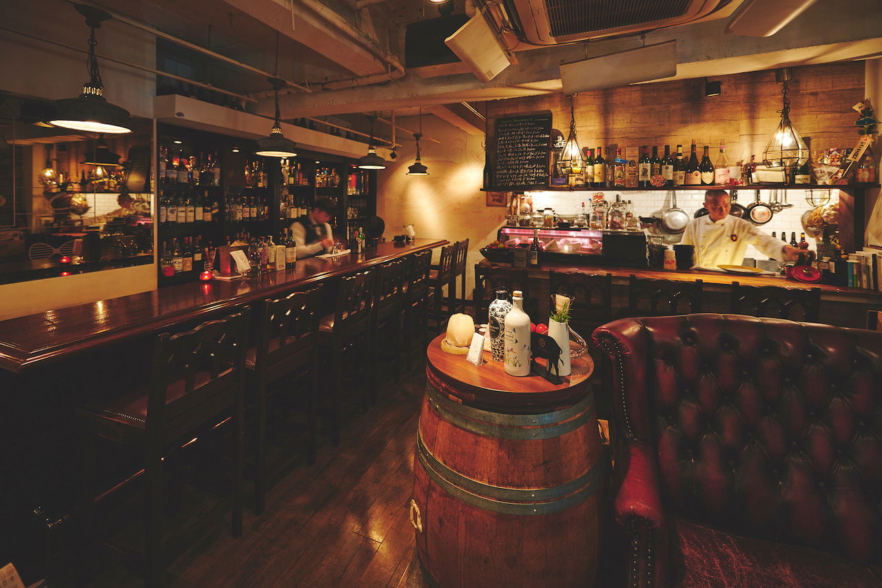 The cozy, dark-wood interiors of Ginza Cave, featuring barrels and an extensive wine list.