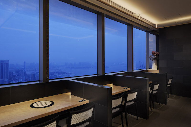 The window seating of Yakiniku Toraji Param Caretta Shiodome on a misty day, Tokyo barely visible in the distance.