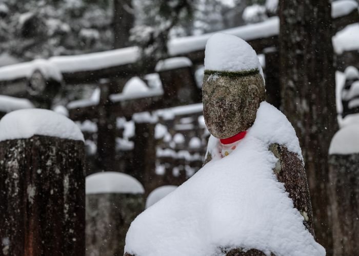 A Japanese statue covered in a layer of snow