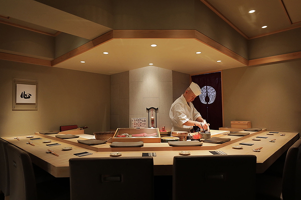 Chef preparing sushi at the counter of a Japanese restaurant