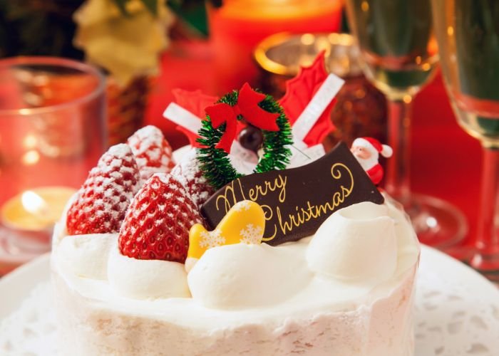 A photo of a strawberry shortcake with Christmas decorations