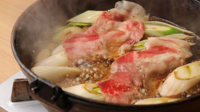 Meat and veggies boiling in a broth at Sukiyaki Kushikatsu Haruna Honmachi.